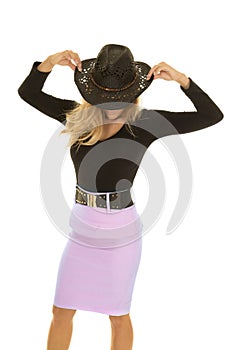 Cowgirl in green skirt head down hold hat