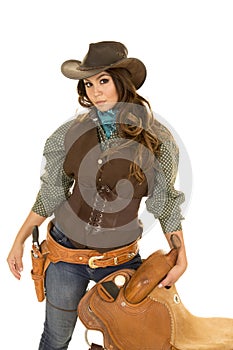 Cowgirl holding saddle hand by gun