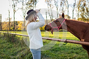Cowgirl playing with her young horse at farm