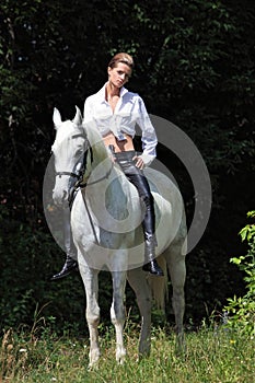 Cowgirl ride back horse in a evening woods