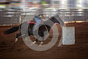 Cowgirl Rides Horse At Speed In Rodeo Barrel Racing Competition