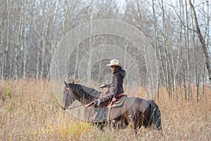 Cowgirl riding her horse photo