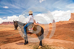 Cowgirl riding horse in Monument Valley Navajo Tribal Park in USA