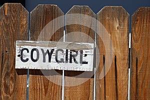 Cowgirl Sign on Fence