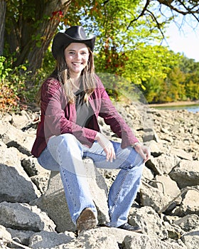 Cowgirl sitting on rocks photo