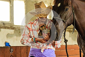 Cowgirl standing next to brown horse friend