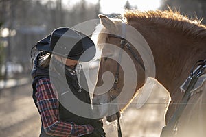 Cowgirl walking with horse in autumn