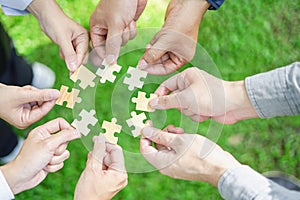 Coworkers hand holding jigsaw puzzle With the cooperation of business people team joins together to campaign Environment, Societ photo