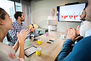 Coworkers applauding a colleague after presentation