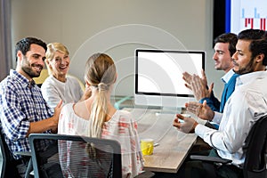 Coworkers applauding a colleague during a video conference