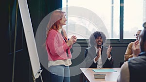 Coworkers applauding and congratulate a woman after a speech