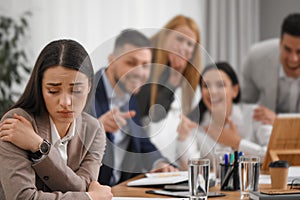 Coworkers bullying their colleague at workplace in office