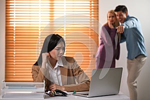 Coworkers bullying their colleague at workplace in office