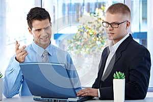 Coworkers discussing work in office