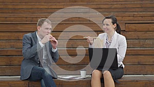 Coworkers eating and chatting outdoors