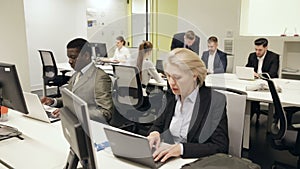 coworkers engaged in business activities in busy open plan office