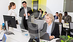 Coworkers engaged in open plan office