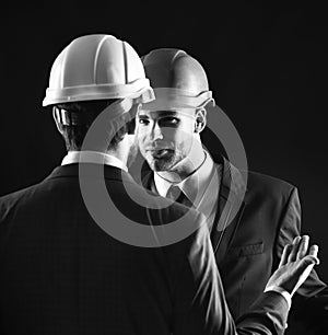 Coworkers in formal suits and building helmets. Construction business concept.