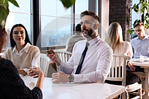 Coworkers having coffee break near window