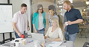 Coworkers with laptop in office