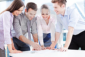 Coworkers leaning over table