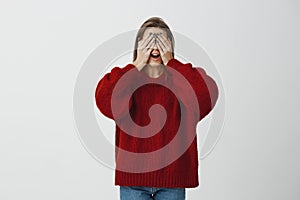 Coworkers preparing surprise for birthday girl. portrait of beautiful mature caucasian woman in red loose sweater