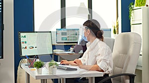 Coworkers with protection face masks working in workplace