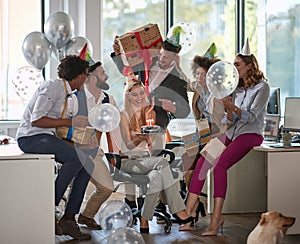 Coworkers surprising female colleague with birthday cake at work in office. surprise, birthday party at work, casual business