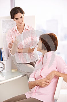 Coworkers talking in office photo