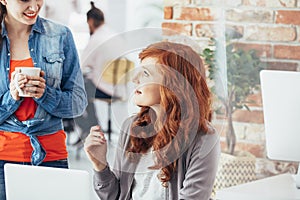 Coworkers talking in office photo