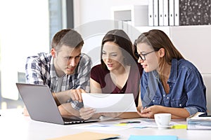 Coworkers working at office comparing data photo