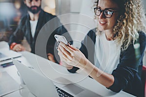 Coworkers working process photo.Young girl in eye glasses working together with bearded colleague at night modern office