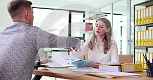 Coworkers working at shared workspaces in company office