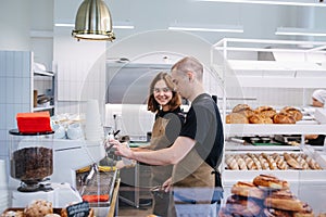 Coworkers, young man and woman socialising in the bakery kitchen