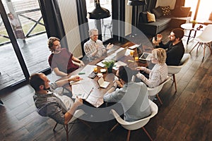 Coworking meeting. Group business people sits around table and w