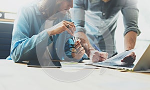 Coworking team brainstorming process in modern office.Project manager analyze reports,holding glasses female hand.Young