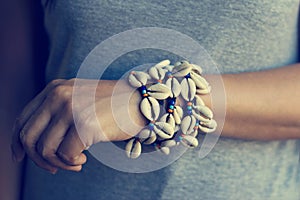 Cowrie shell bracelets on the wrist of woman