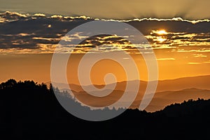 Mountain landscape silhouette at sunrise. Sun hidden behind the clouds. Vrsatec, Slovakia