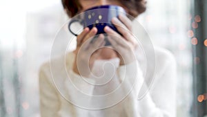 Cozy atmosphere girl with big cup coffee cacao chocolate christmas time winter. Close up young woman`s hands holding big