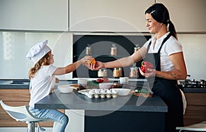 Cozy atmosphere. Mother with her daughter are preparing food on the kitchen