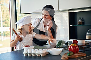 Cozy atmosphere. Mother with her daughter are preparing food on the kitchen