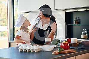 Cozy atmosphere. Mother with her daughter are preparing food on the kitchen