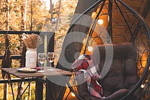 cozy autumn date outdoor. two glasses of wine, warm blanket, garland and candle lights, swedish hygge concept.