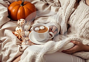 Cozy autumn at home,Woman drinking tasty pumpkin coffee on bed. A cozy way of life . AI Generated