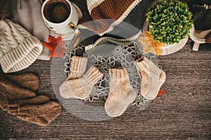 Cozy autumn still life with cup of hot black coffee. knitted hat and scarf on wooden background