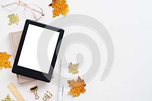 Cozy autumn workspace. Home office desk table with ebook mockup, maple leaves and glasses on white. Flat lay, top view, copy space