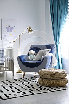 Cozy baby room interior with armchair