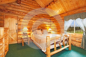 Cozy bedroom in log cabin house