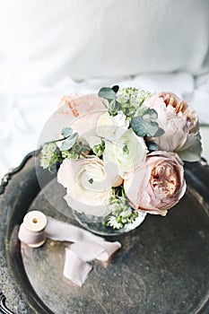 Cozy bedroom still life scene. Wedding, birthday bouquet of pink English roses, Ranunculus and Astrantia flowers and