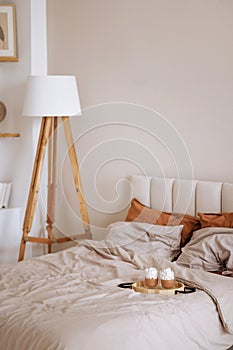 Cozy bedroom with unmade bed and breakfast on a tray.